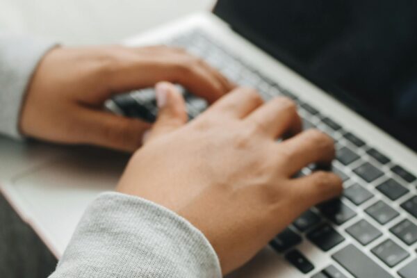 Dłonie osoby piszącej na klawiaturze laptopa - dostępność cyfrowa i nawigacja klawiaturą