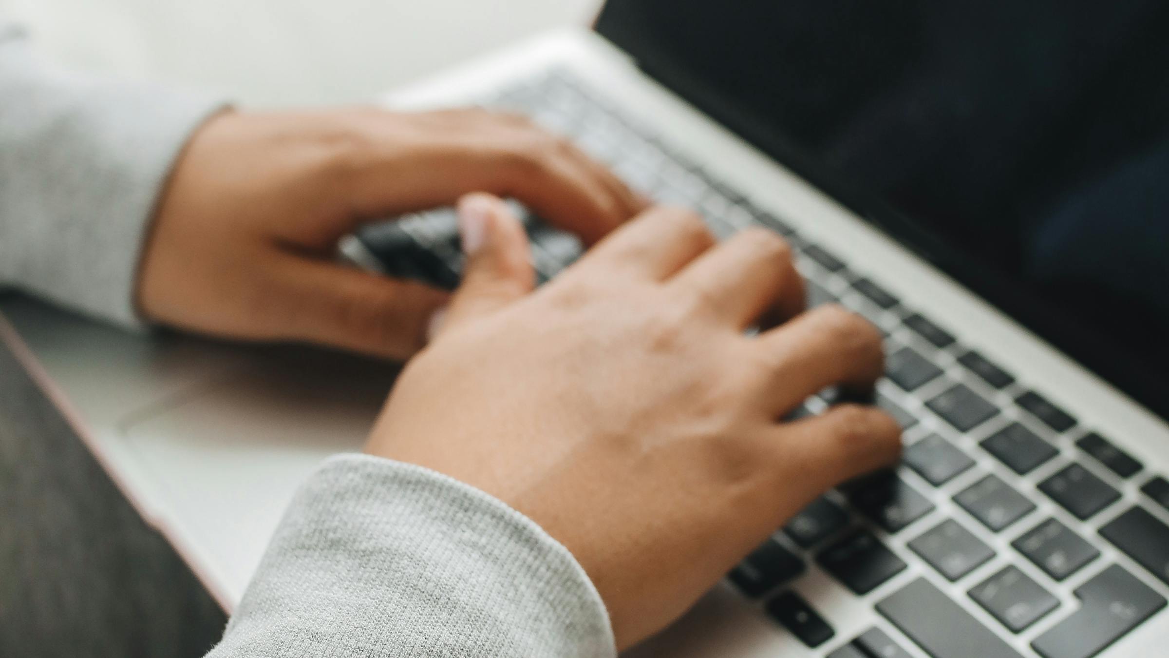 Dłonie osoby piszącej na klawiaturze laptopa - dostępność cyfrowa i nawigacja klawiaturą